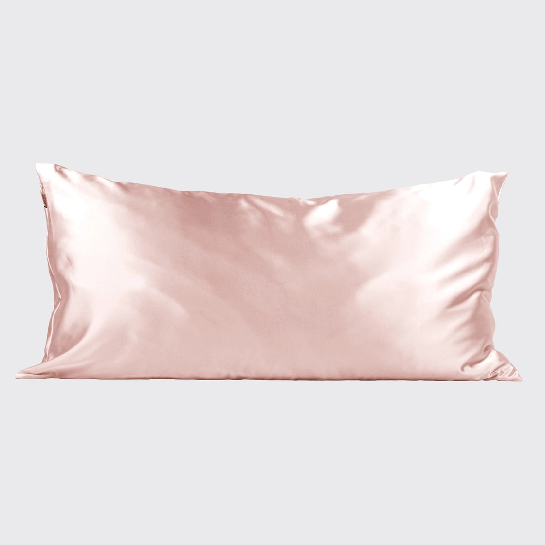 Blush pink satin pillowcase with lustrous sheen and smooth finish, rectangular shape on neutral background