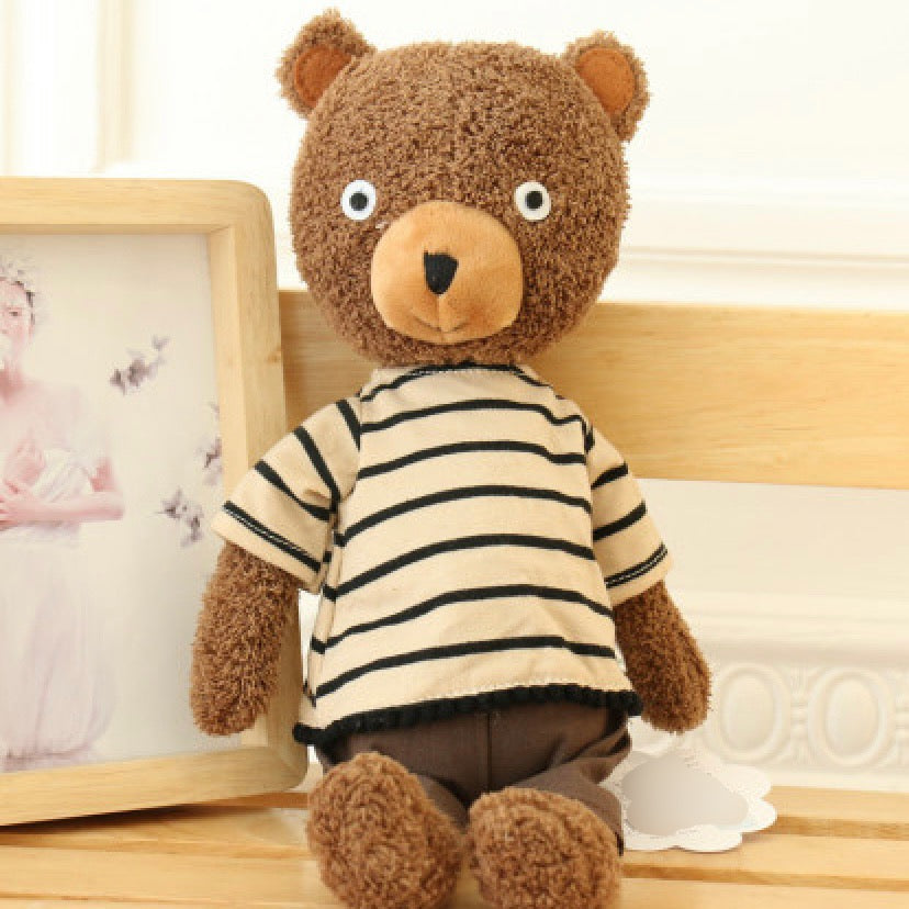 Plush teddy bear in brown curly fabric wearing cream and black striped shirt with tan felt snout and white button eyes