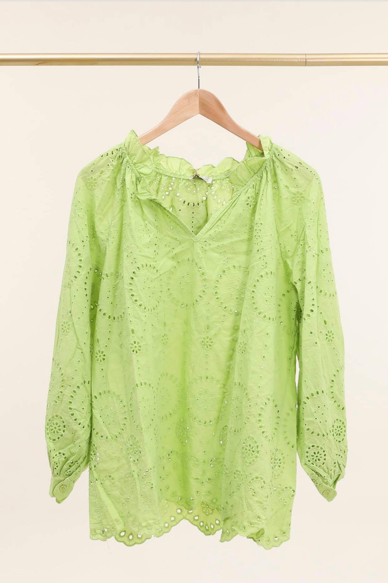 Lime green cotton eyelet blouse with scalloped ruffle collar, long sleeves, and floral cutwork embroidery on wooden hanger