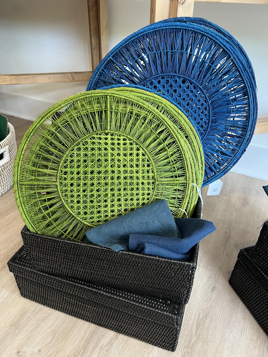 Round woven placemats in lime green and bright blue with intricate radiating spoke pattern and lattice center design