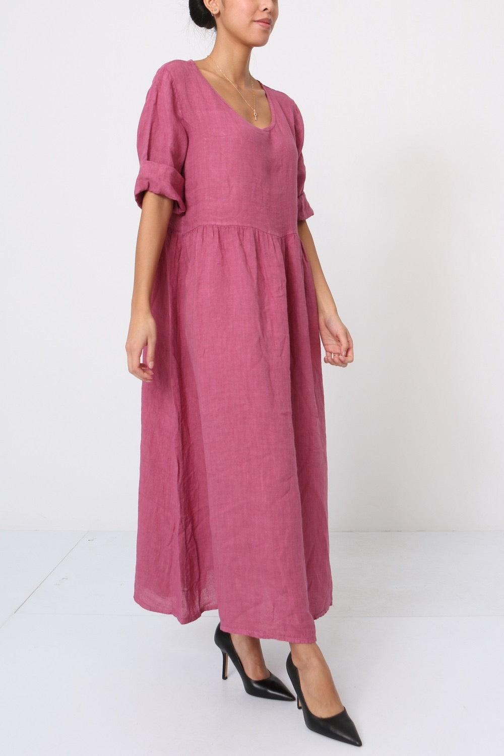 Mauve pink linen maxi dress with gathered waist, puffed short sleeves, and scoop neckline on white background