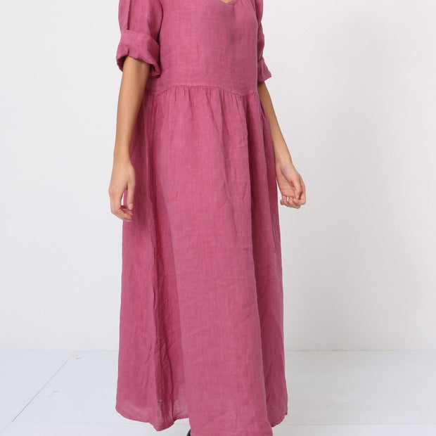 Mauve pink linen maxi dress with gathered waist, puffed short sleeves, and scoop neckline on white background