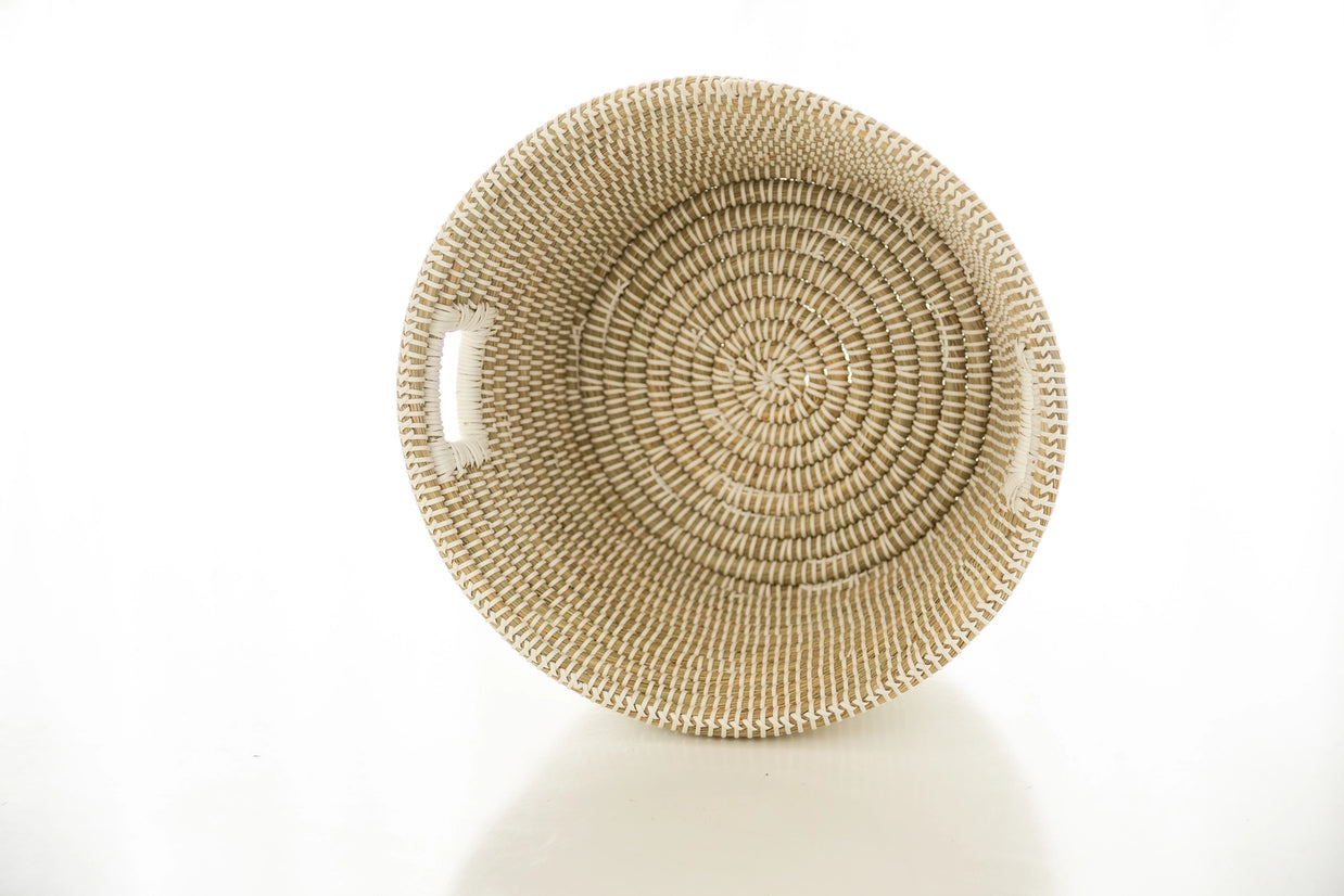 Handwoven natural seagrass basket bowl with coiled spiral pattern in cream and tan tones viewed from above
