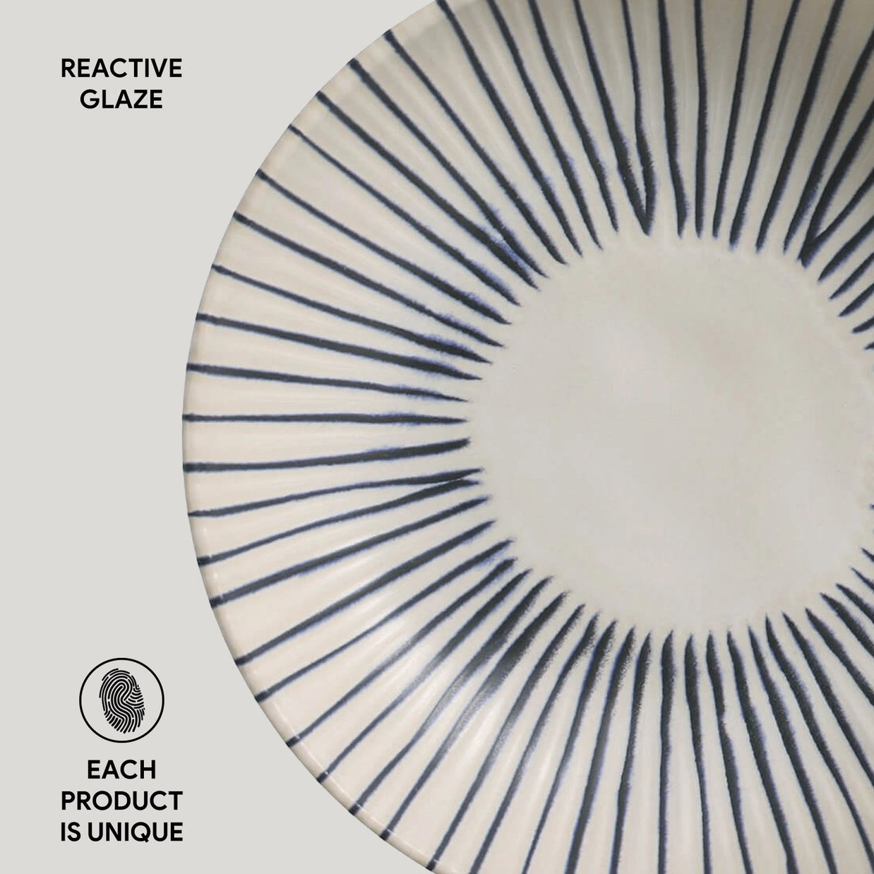 Ceramic plate with navy blue radiating lines from center in sunburst pattern on cream white reactive glaze surface