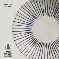 Ceramic plate with navy blue radiating lines from center in sunburst pattern on cream white reactive glaze surface
