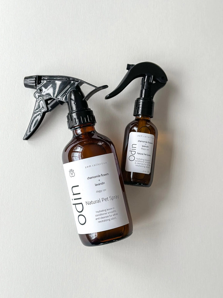 Two amber glass spray bottles with black trigger nozzles labeled Ulpo Natural Pet Spray with chamomile and lavender scents