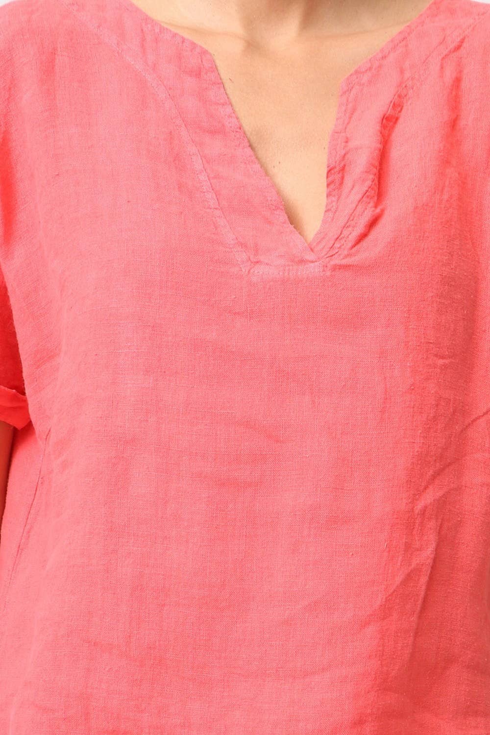 Coral pink linen tunic with V-neck and subtle slub texture shown on model torso detail shot