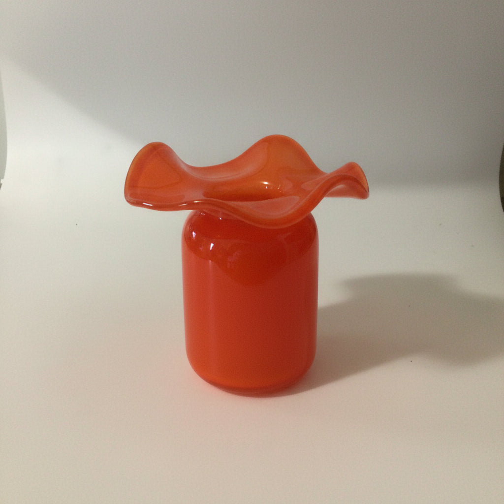 Coral orange glass vase with ruffled flared rim and cylindrical base in glossy translucent finish