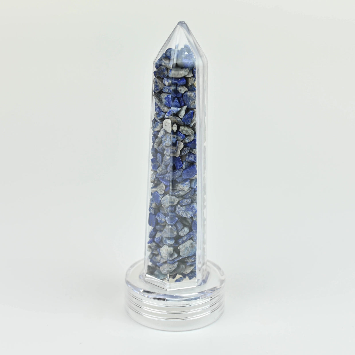 Clear acrylic obelisk tower filled with tumbled lapis lazuli gemstone chips in deep blue and gray tones on round base