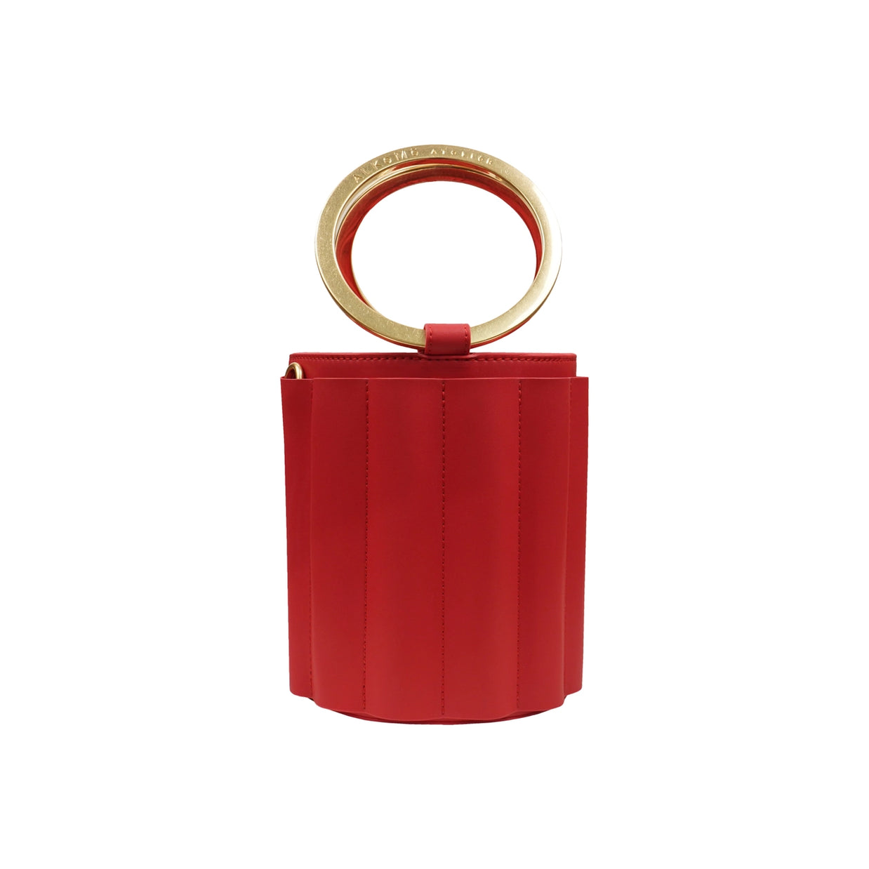 Red leather cylindrical bucket bag with vertical stitching and brass circular ring handle on white background