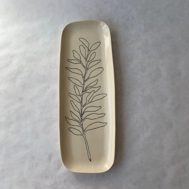 Elongated cream ceramic tray with hand-drawn black line art botanical leaf design, featuring rounded corners and glossy finish