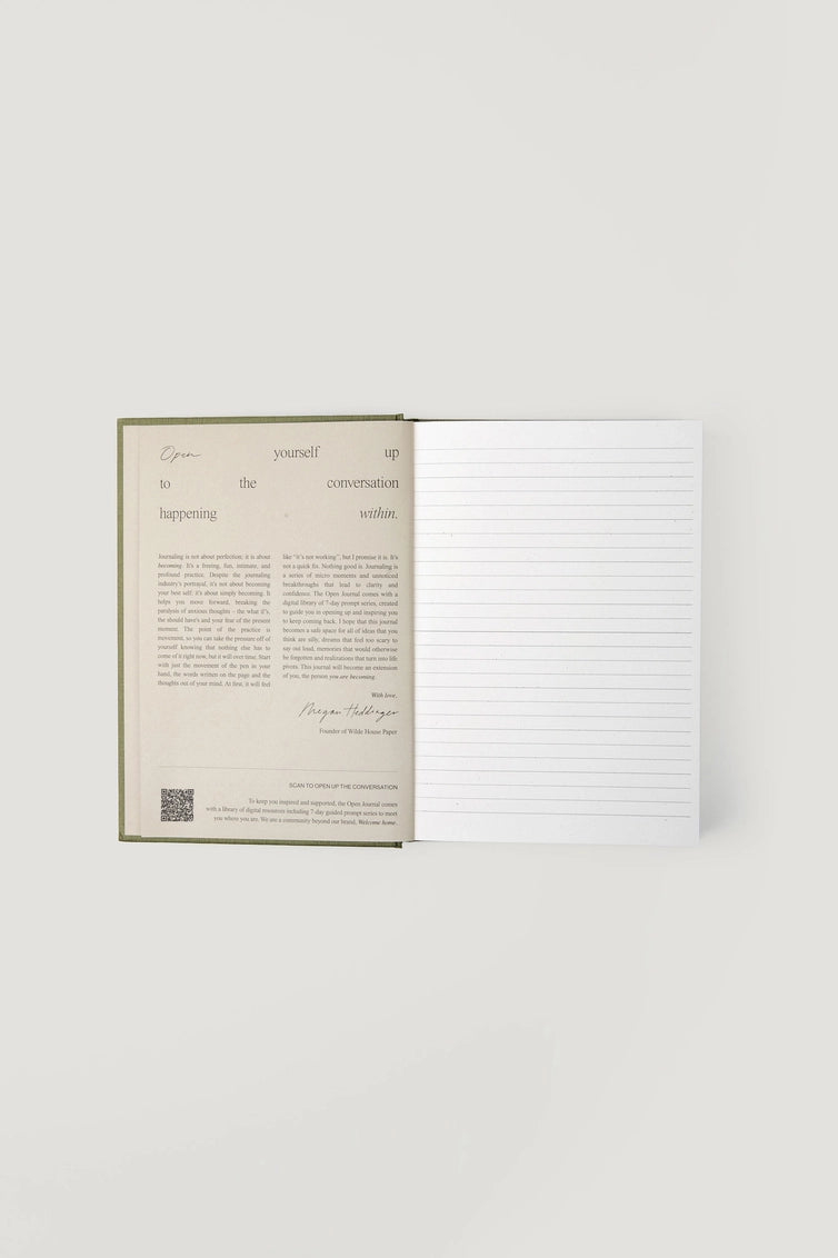 Open hardcover journal with cream pages featuring inspirational text and lined writing pages on sage green cloth binding