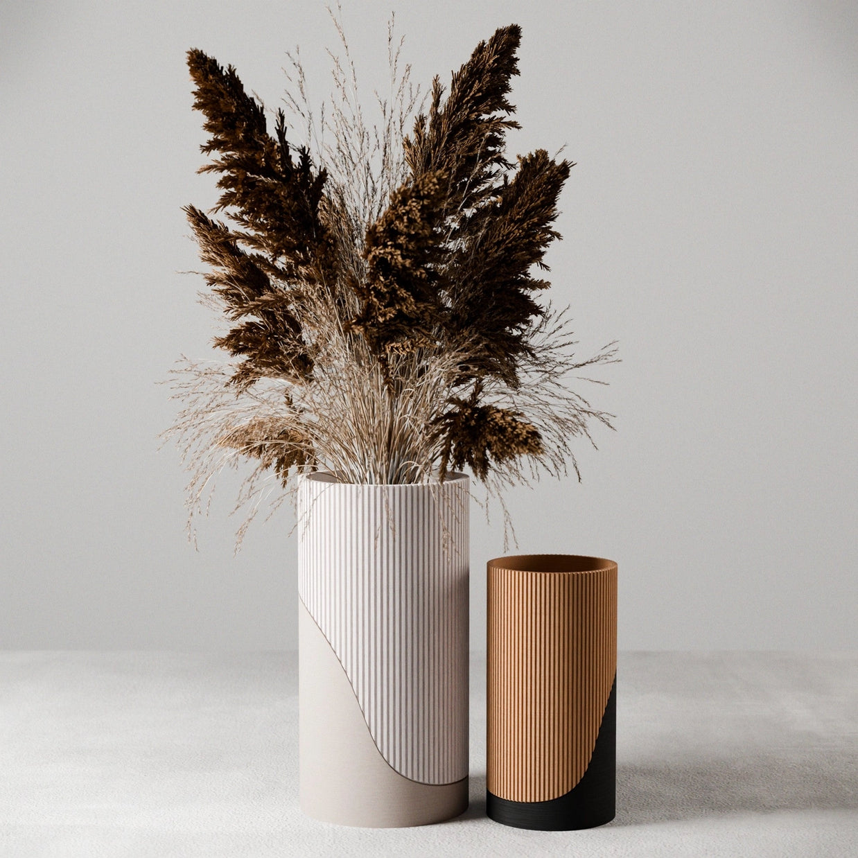 Pair of ribbed ceramic vases with vertical texture, white tall vase with dried pampas grasses and smaller caramel brown vase
