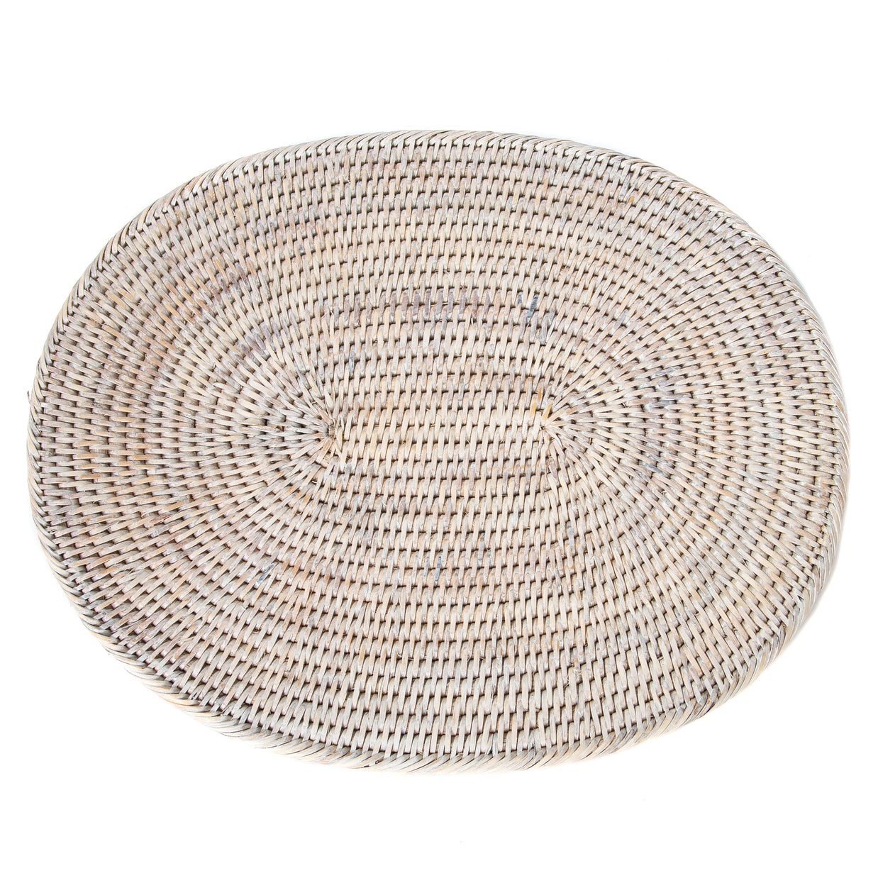 Oval whitewashed rattan placemat with tightly woven natural fibers radiating from two center points in spiral pattern
