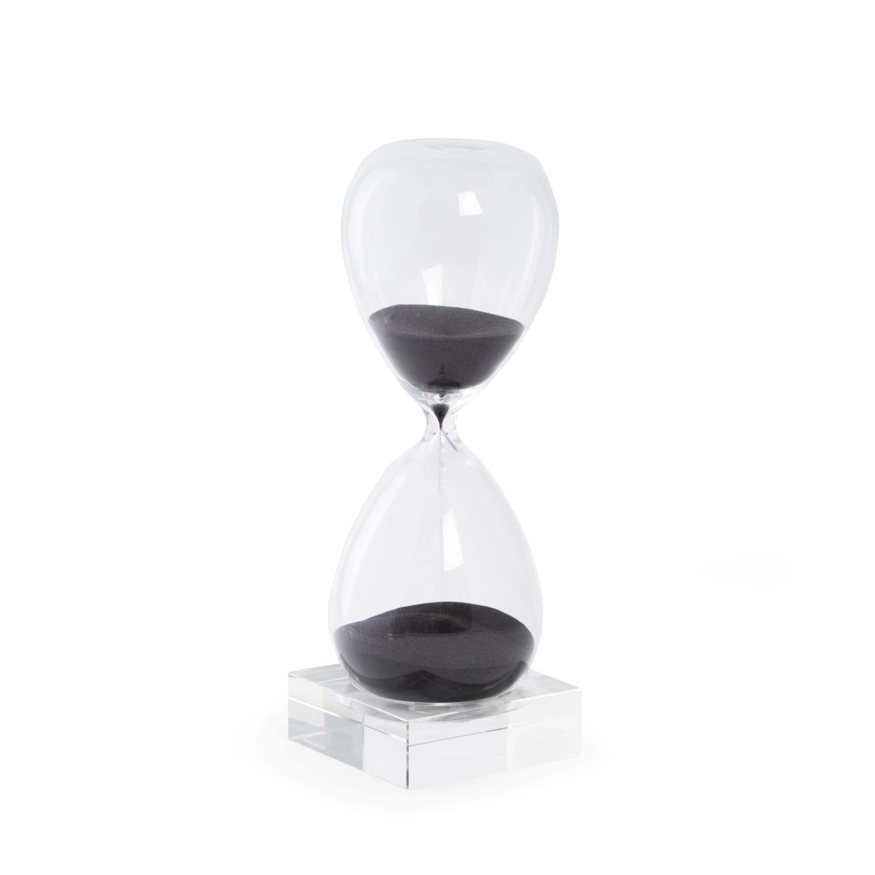 Clear glass hourglass with black sand on transparent acrylic base, sand actively flowing between two bulbous chambers
