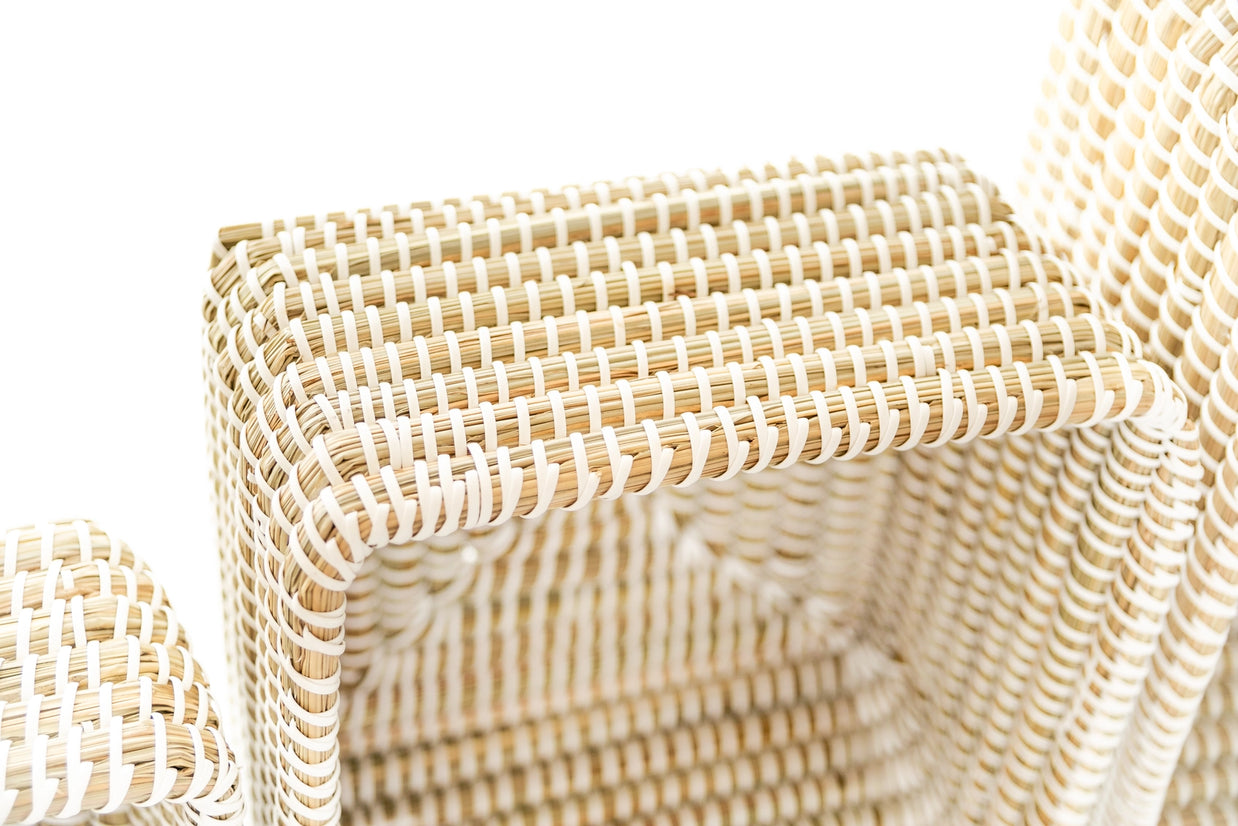 Handwoven kaisa grass storage basket with natural tan base and white woven pattern in geometric cube shape with lid
