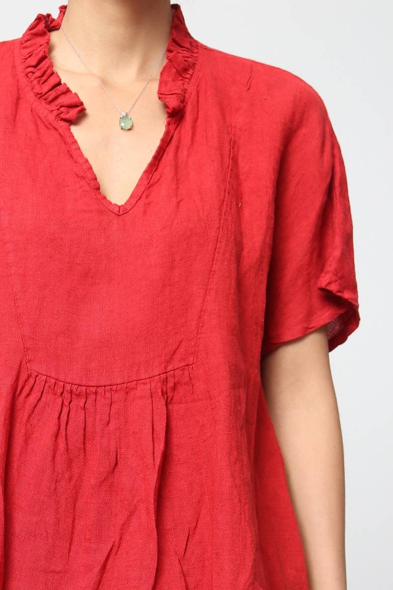 Coral red linen dress with ruffled v-neckline, gathered waist seam, short sleeves, and delicate mint green pendant necklace