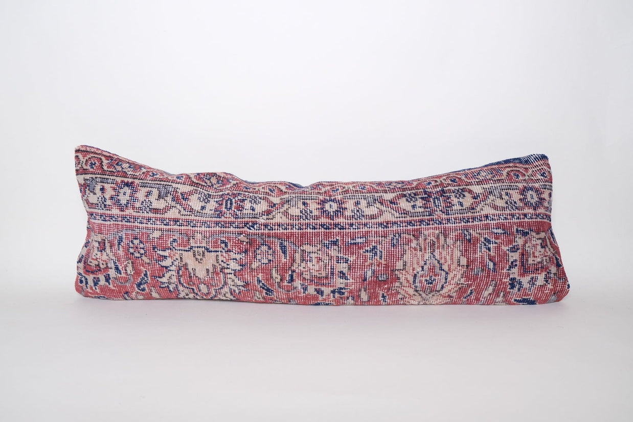 Rectangular lumbar pillow made from vintage Turkish rug with coral pink, navy, and cream floral medallion pattern
