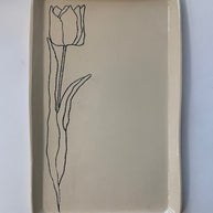 Cream ceramic rectangular tray with hand-drawn black line illustration of a single tulip flower with stem and leaves