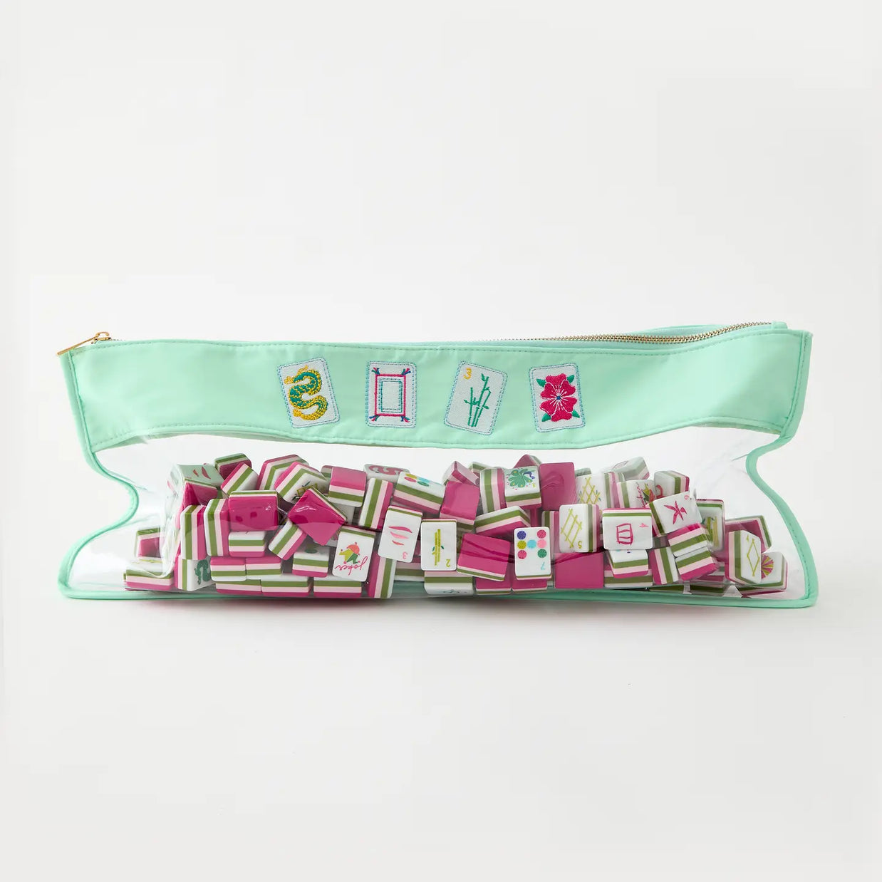 Mint green vinyl mahjong tile bag with gold zipper and embroidered tile patches, filled with pink and green striped tiles