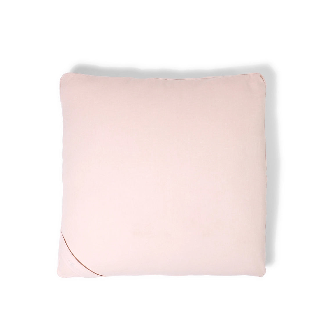 Square throw pillow in soft blush pink fabric with piped edges and smooth matte finish on white background