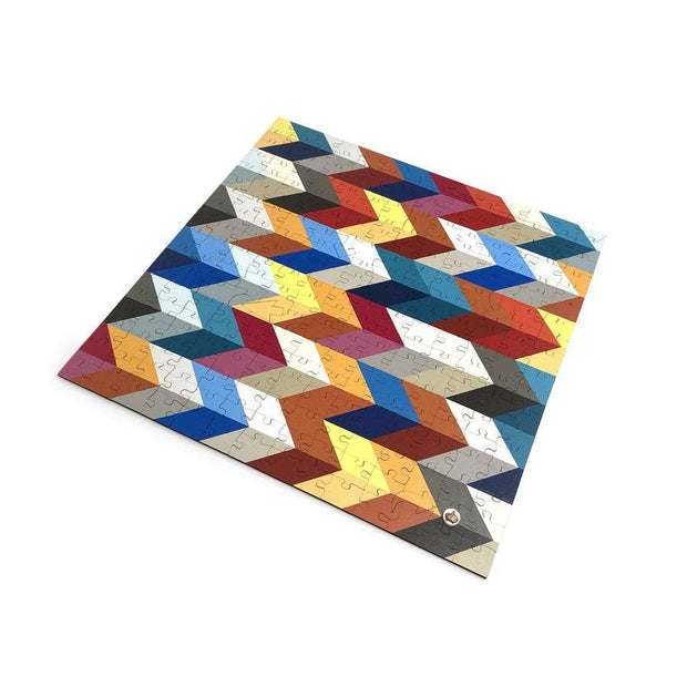 Jigsaw puzzle with colorful geometric chevron pattern in blues, reds, yellows, oranges, and grays on white background