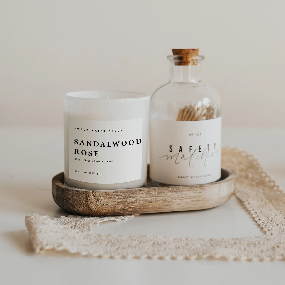 White frosted glass Sandalwood Rose candle and Safety Matches jar with cork stopper on wooden tray with lace cloth