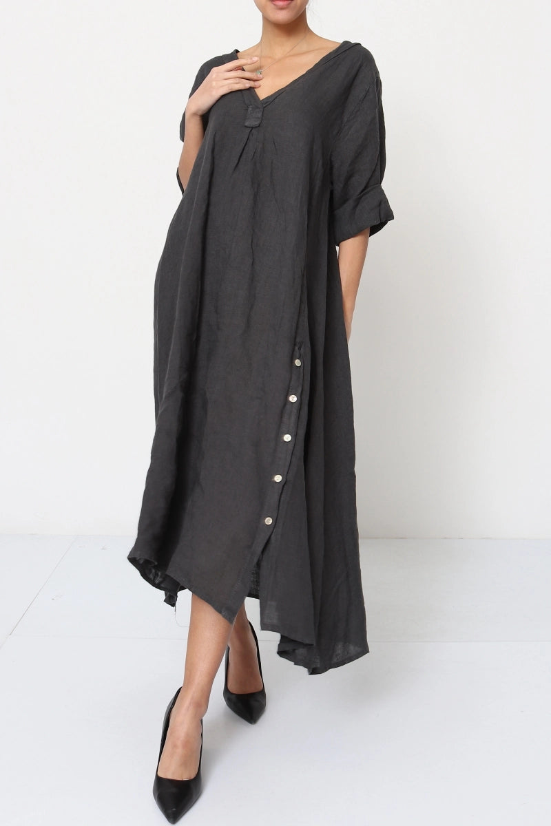 Charcoal gray linen oversized midi dress with v-neck, rolled sleeves, asymmetric hem and white button detail down side seam