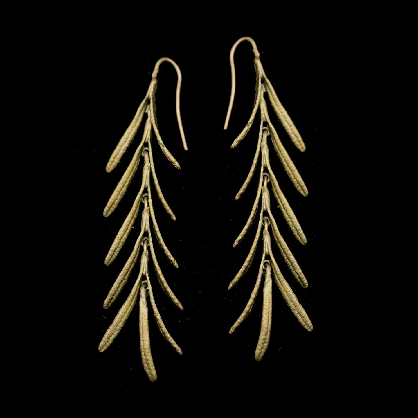 Brass botanical earrings with cascading rosemary sprig design featuring multiple delicate leaves on curved wire hooks