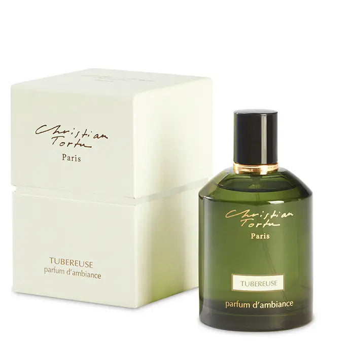 Green gradient glass bottle with black cap and gold accents next to cream-colored Christian Tortu Paris Tubereuse box