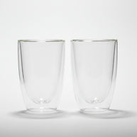 Two clear glass tumblers with a brand logo on a white background