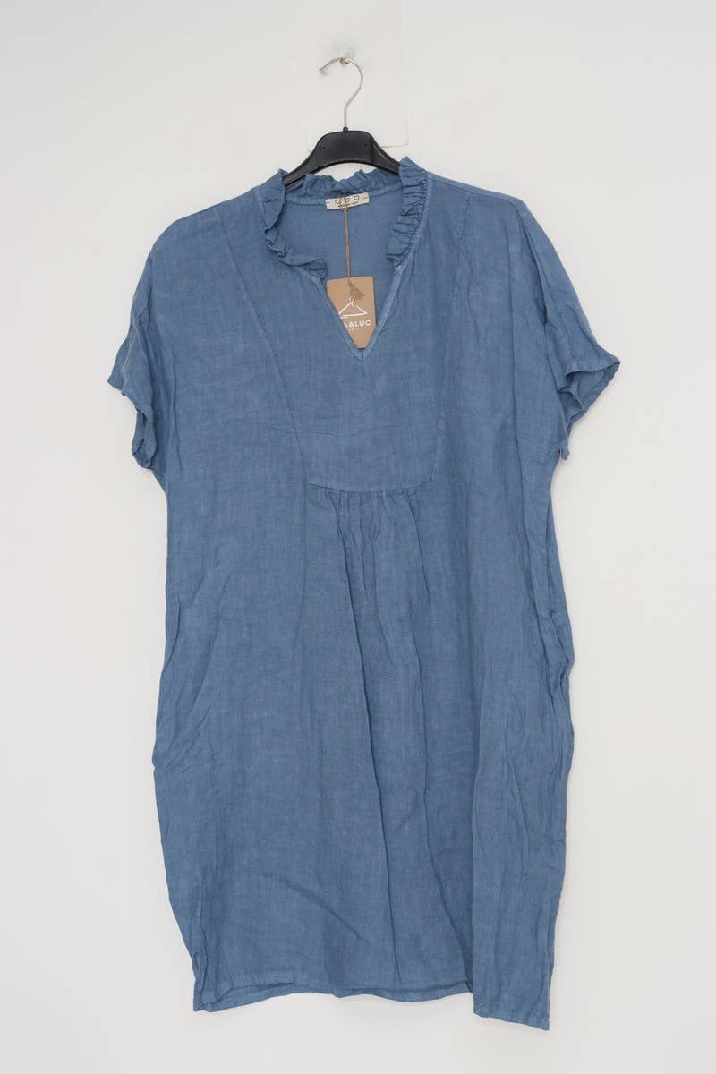 Slate blue linen shift dress with short sleeves, ruffled V-neck, gathered waist detail, hanging with kraft paper tag
