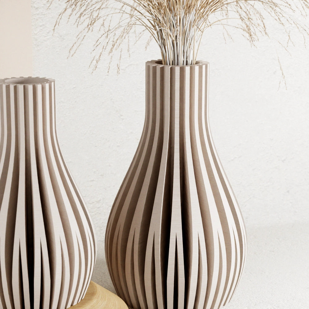 Natural wood vases with vertical slatted design in bulbous teardrop shape filled with dried beige grass stems