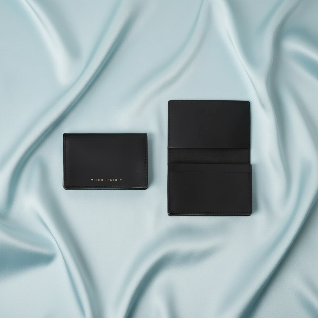 Black leather card holder with gold Minor History text, shown closed and open revealing multiple card slots and stitching