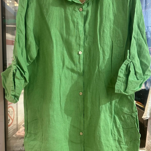 Bright grass green linen tunic with collar, white button front, and rolled three-quarter sleeves on white hanger