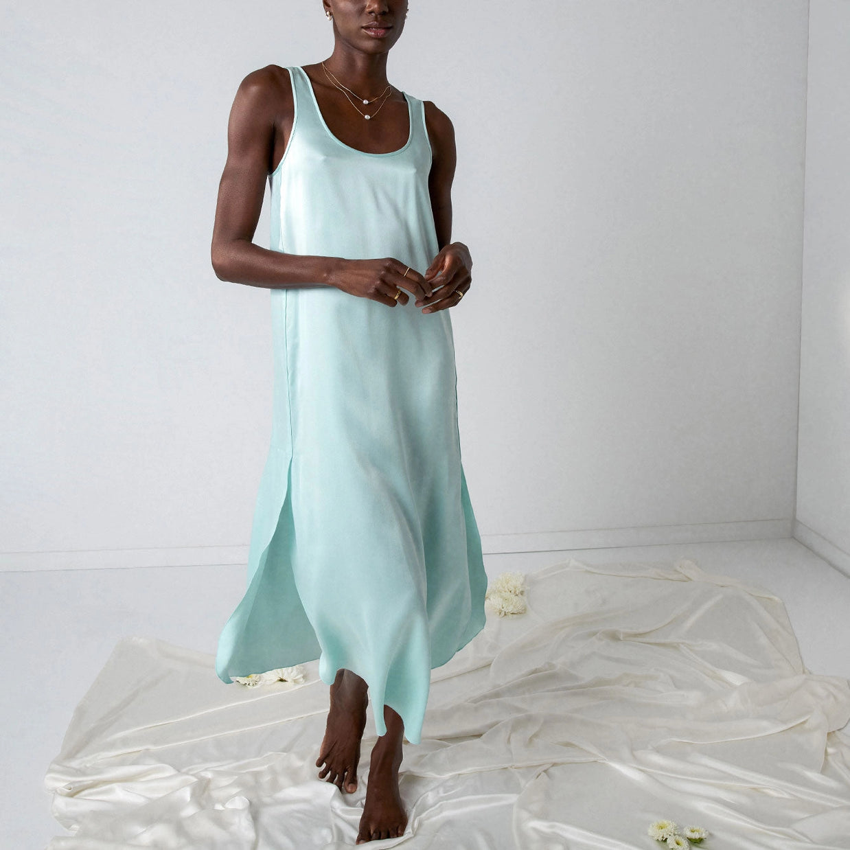 Light mint green silk sleeveless maxi dress with scoop neck, relaxed fit, and flowing asymmetrical tulip hem