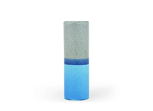 Cylindrical ceramic vase with two-tone glaze: speckled sage green upper half and gradient blue lower half on white background