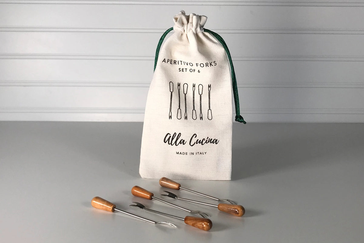 Set of six aperitivo forks with wooden handles and stainless steel tines displayed beside natural canvas drawstring pouch