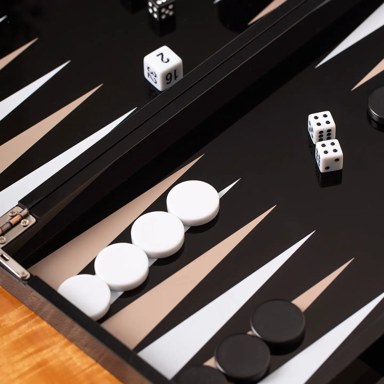 Black backgammon board with white and tan triangular points, white dice showing double sixes, and white and black playing pieces