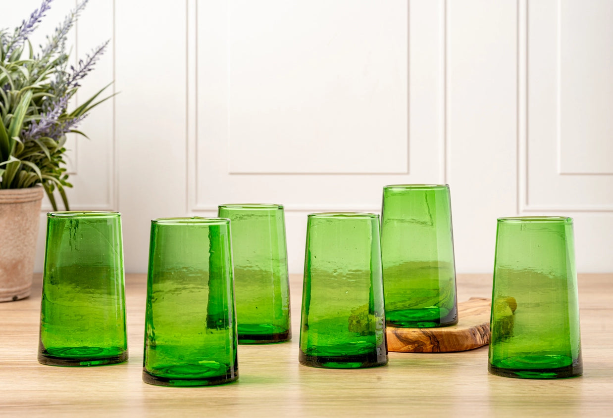 Set of six emerald green hand-blown glass tumblers with tapered cone shape and textured finish on wood surface