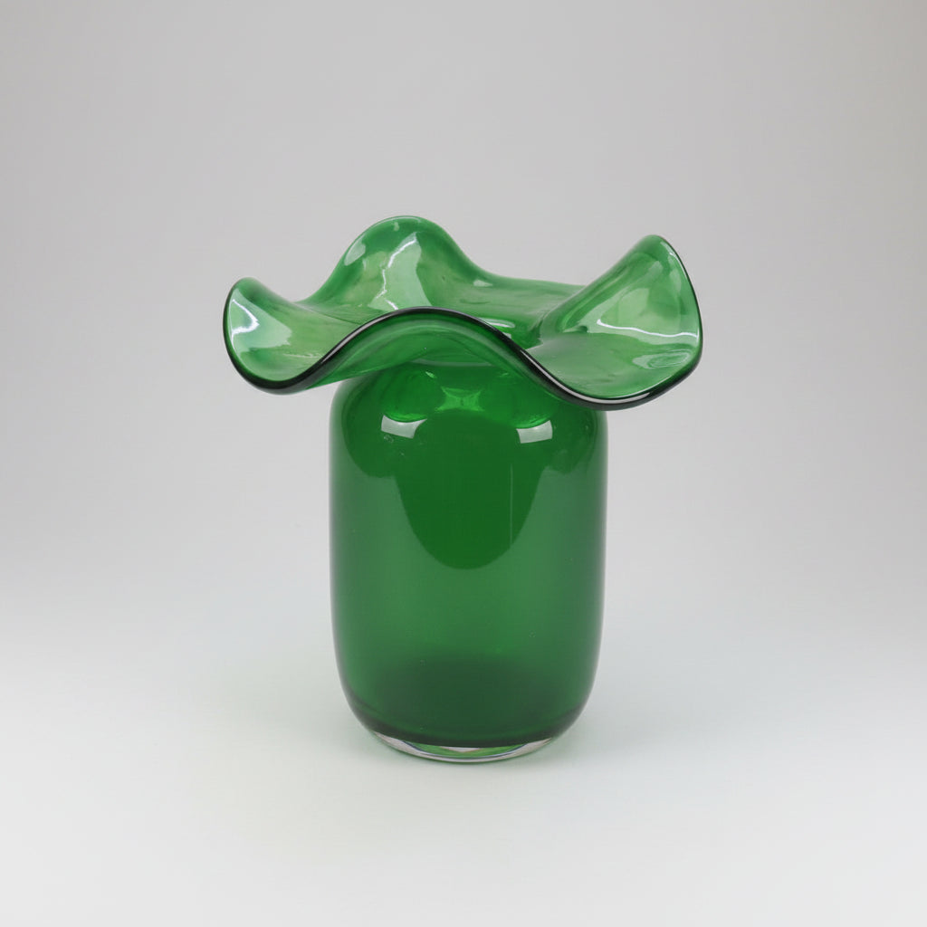 Green gradient glass vase with ruffled organic wavy rim and smooth cylindrical body on neutral surface
