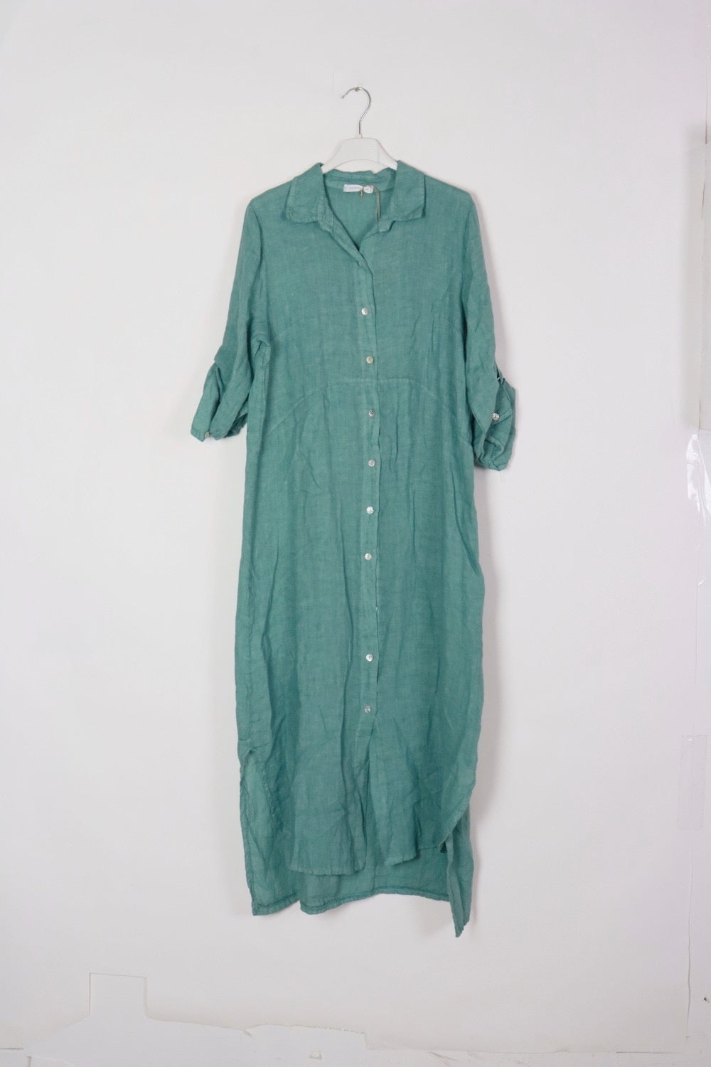 Seafoam green linen shirt dress with white button front, collar, rolled tab sleeves, and relaxed maxi length silhouette
