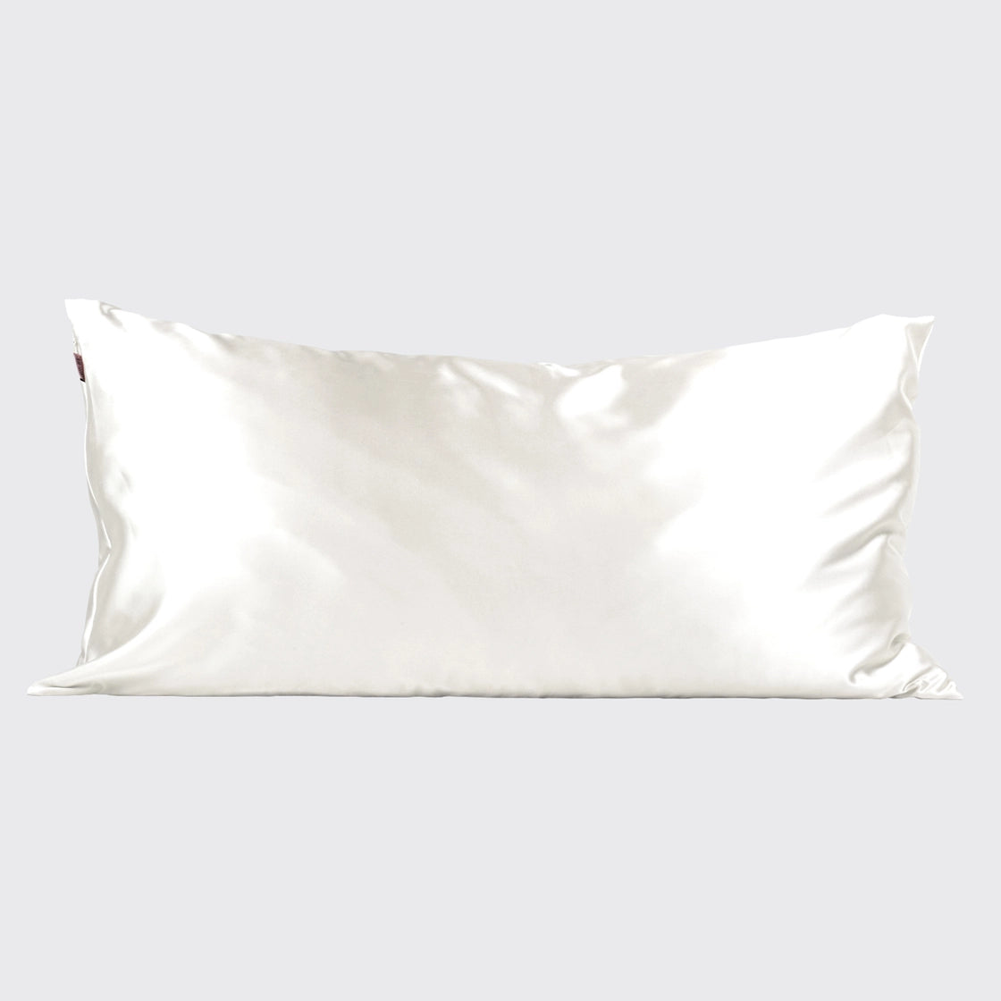 Ivory silk satin pillowcase with luminous sheen and smooth lustrous finish, shown lying flat against neutral background