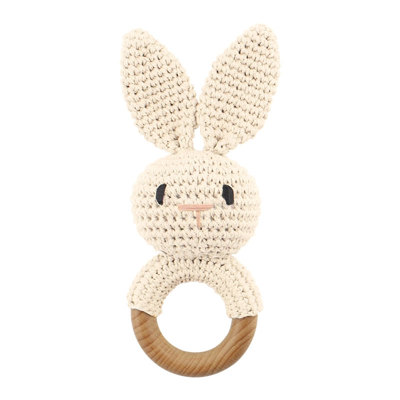 Cream crocheted bunny baby teether with natural wood ring base, tall ears, and embroidered face details
