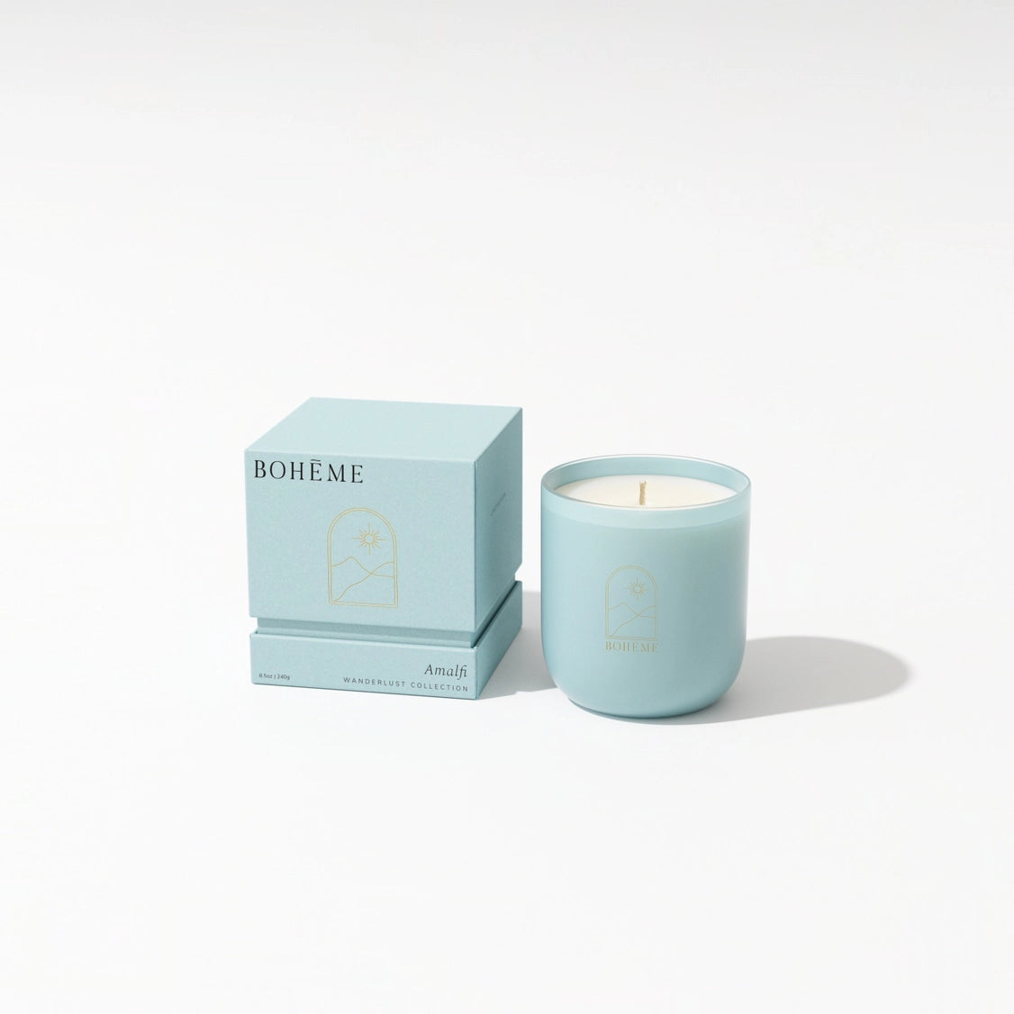 Powder blue ceramic candle in rounded vessel with cream wax and matching gift box featuring gold arch motif and Bohème branding