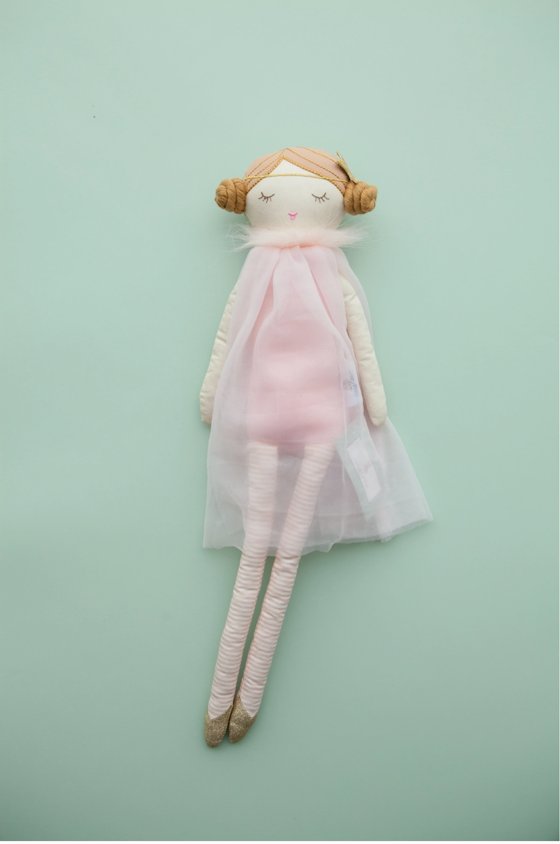 Soft fabric ballerina doll with tan yarn hair buns, pink tulle dress, striped legs, and gold glitter ballet shoes