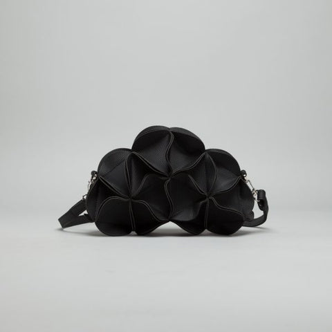 Black leather sculptural shoulder bag with ruffled petal-like texture and adjustable crossbody strap with silver hardware