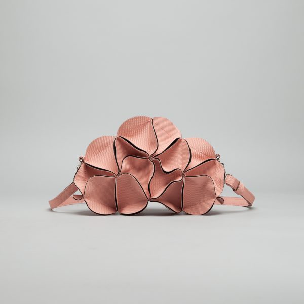 Rose gold leather crossbody bag shaped like clustered flower petals with dark burgundy piped edges and chain strap