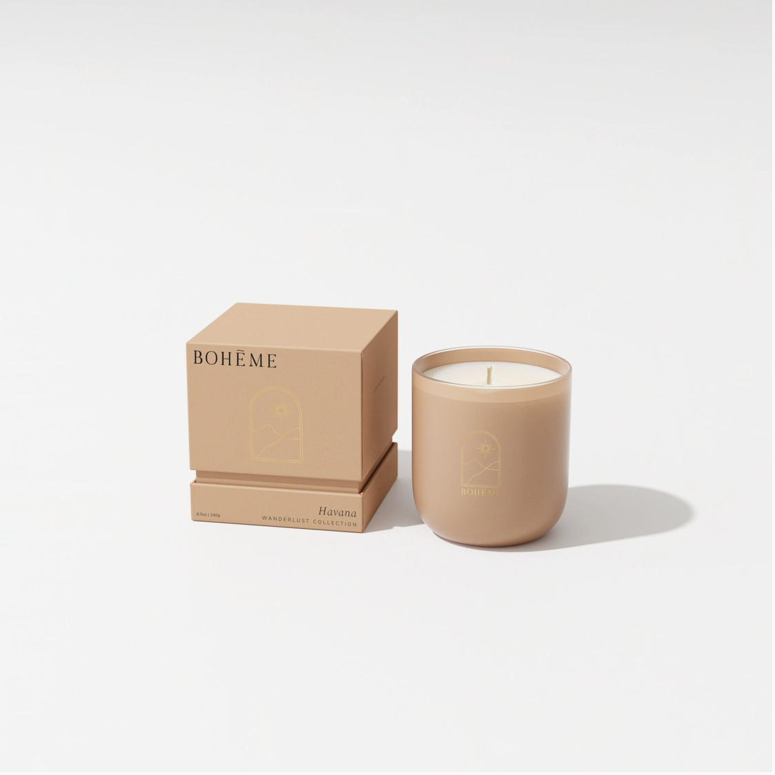Bohème Havana scented candle in matte beige ceramic vessel with white wax beside matching cubic gift box on white surface