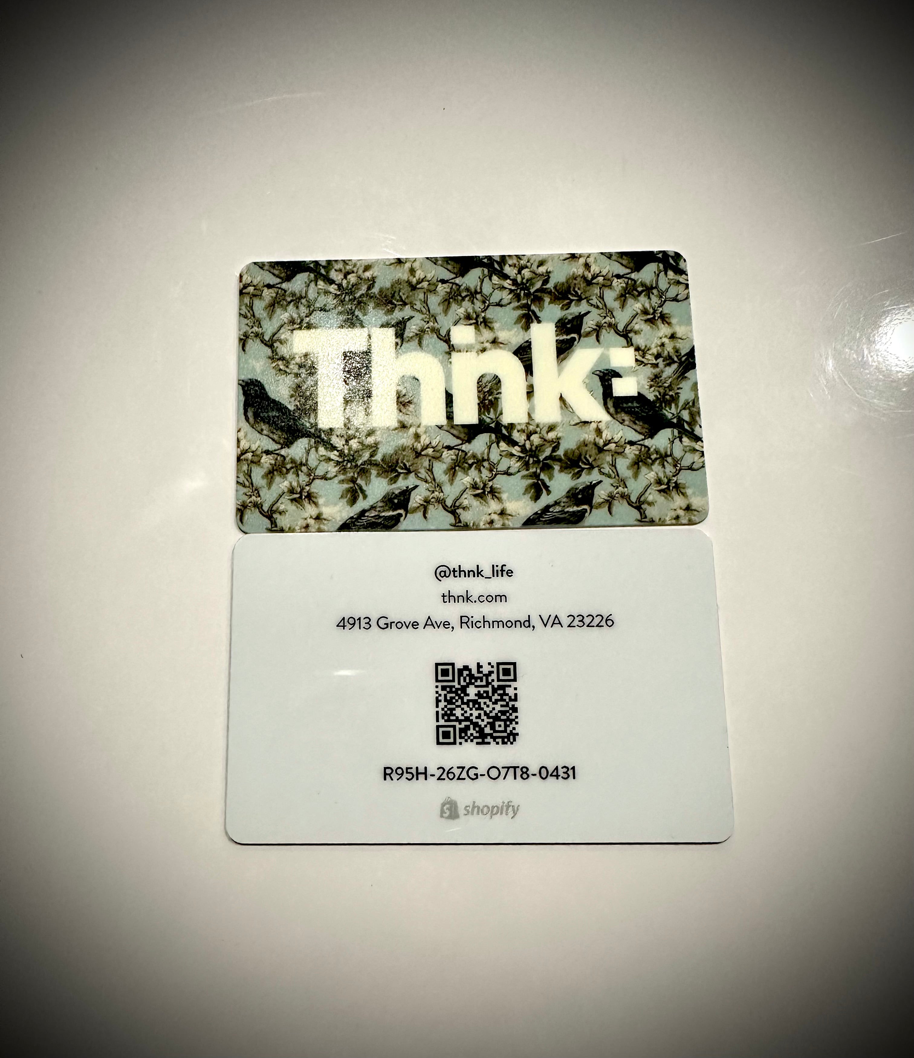 A plastic gift card with a camouflage pattern and the brand name 'Thnk' displayed prominently in the center.